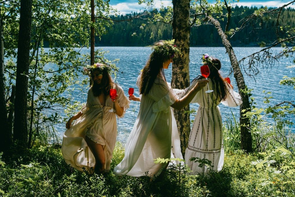 A group of women standing next to each other near a lake