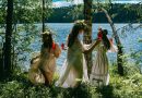A group of women standing next to each other near a lake