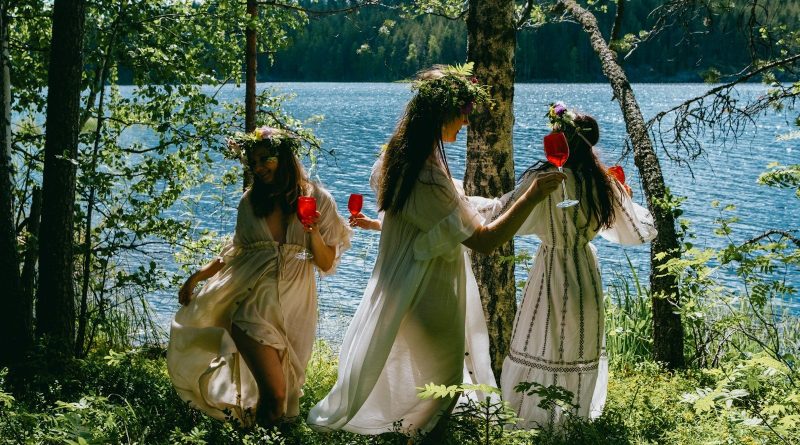 A group of women standing next to each other near a lake